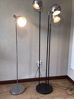 Both lamps upright against textured wall, lamps lit