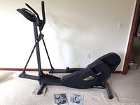 Side view of NordicTrack E7 elliptical showing full frame, foot pedals, and console stand.