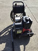 Front three-quarter view showing engine, pump, wheels and handle