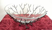 Photo showing entire glass bowl on the black metal stand with branch-like supports.
