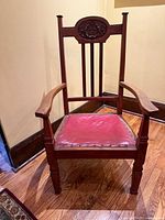 Front view of mahogany armchair with red leather seat