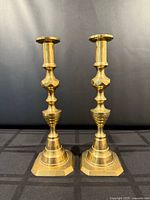 Front view of both brass candlesticks standing upright