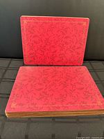 Stack of placemats showing red patterned tops and thickness