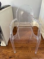 Front view of clear acrylic armchair showing seat, arms, and back