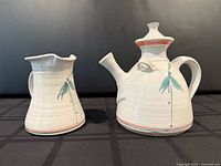 Teapot and milk jug side by side showing size comparison and design motif