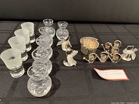 Group shot of all items: vases, shot glasses, watering can holders, basket, bell holders