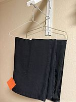 Both black tablecloths folded on hangers