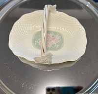 Top view of white Mikasa porcelain basket dish showcasing the textured basket weave design, central floral pattern, and gold trim.