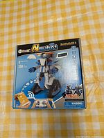 Front view of the AI MUBOT robot building kit box showing robot image, piece count, age recommendation, and control features.