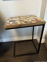 Side view of the side table showing wooden top and black metal frame base