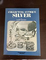 Cover of the book showing title and a black and white photo of antique silver items