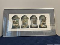 Full view of the large rectangular framed artwork showing four arched windows with seasonal scenes.