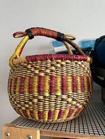 Side view of the woven basket highlighting the pattern and leather-wrapped handle.