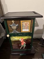 Front view of vintage wooden side table showing golf-themed decorative panel on front door with golfer figurine, trophy plaque, and golfing print.