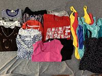 Top view of multiple T-shirts including striped, printed, and solid colors