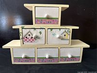 Front view of the vintage wooden jewelry/trinket box showing six drawers with painted designs.