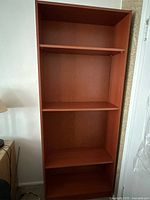 Full view of the solid wood bookcase showing three shelves and overall structure.