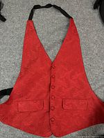 Red tuxedo vest with textured paisley polyester satin fabric, button closure, and non-functional pockets