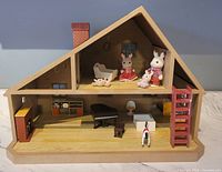 Full view of the wooden Calico Critter dollhouse with rabbit family figures displayed on upper floor and furniture on lower floor