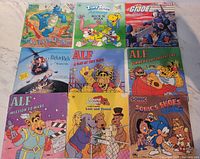 Front covers of 9 books showing titles and cartoon characters from 1980s-90s Saturday morning cartoons including ALF, Sonic, G.I. Joe, Richie Rich