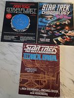 Three softcover Star Trek books: Star Fleet Technical Manual 2nd printing, Star Trek Chronology, and Star Trek The Next Generation Technical Manual.