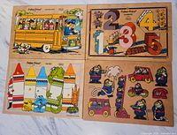 Lot of five vintage Fisher Price children's board puzzles arranged on floor showing colorful wooden puzzle pieces and puzzle boards.