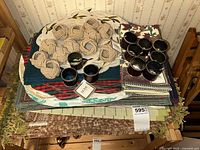 Assorted placemats stacked with cloth napkins and napkin rings displayed on top