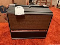 Full view of Bell and Howell Compatible Filmosound II movie projector showing woodgrain panel and black casing.