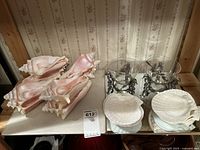 Photo showing the full set of scalloped shell serving dishes, conch shell soul bowls with spoons, and glass serving bowls with seahorse bases arranged on display.