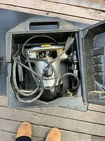 Open black plastic carrying case containing a Craftsman router with attached power cord, showing dust and minor wear.