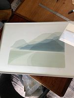 Photo of the framed vintage fine art print showing minimalist mountain landscape in muted green tones.