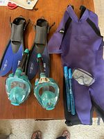 Photo showing full face snorkel masks, flippers, shortie wetsuit, small snorkel mask, and bubble wands.
