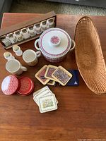 Full lot overview including casserole, spice rack with jars, mugs, coasters, cards, basket