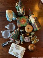 Overview of all vintage collectibles including figurines, small vases, decorative containers, and glass spheres on wood surface