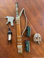 Photo of the entire lot showing the Dao sword, carved betel nut box, lock pick tool, model train cars, and wooden figurine on wooden surface.