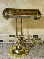 Front view of vintage brass desk lamp with punch hole shade on a kitchen counter