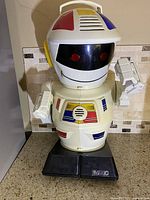 Front view of the vintage Emiglio Scooter robot with colorful details and black base, remote included shown separately.
