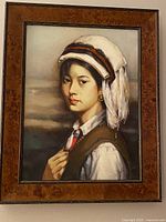 Full view of framed portrait of young girl in traditional attire on canvas with original Italian frame.