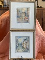 Both paintings displayed together showing frames, mats, and signatures