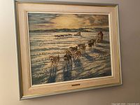 Framed vintage Inuit dog sled textured art print on canvas showing a sled team of dogs on snow with a person driving the sled.