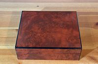 Closed view of the cigar humidor showing polished reddish-brown exterior wood finish.