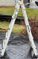 Full view of the Mastercraft articulating aluminum ladder set up in an A-frame position on a driveway.