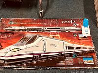 Box showing Renfe AVE S102 bullet train graphic with text in Spanish describing electric train set.