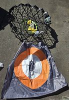Folded net and circular target laid out on ground, showing size and materials