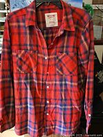 Front view of Mossimo red plaid flannel shirt showing button front, collar, and chest pockets