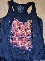Front view of black sleeveless tank top with printed graphic of a cat with pizza motif on fur.
