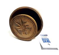 Antique wood butter mold showing the circular hand-carved sheaf design on the mold face