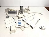 Two Apple iSight cameras with mounts and cables, Apple iPod Shuffle with cable, three Apple remotes, four Apple video adapters for s-Video, HDMI, VGA, and DVI, plus one VGA to DVI adapter laid out on white background.