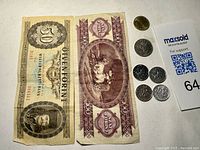 Two Hungarian banknotes 50 Forint and 100 Forint with Hungarian 5 Forint coin, Austrian 5 Schilling coin, and three Czech Koruna coins.
