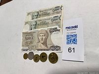 Three Greek Drachma banknotes: two 500 drachma and one 1000 drachma note alongside five coins in denominations 1,10,20,50,100 drachma.